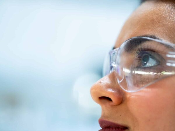 Woman wearing safety goggles, seen in profile
