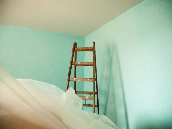 Ladder in an empty room covered with plastic sheeting, ready for painting