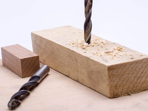 Drill bit boring into a block of wood