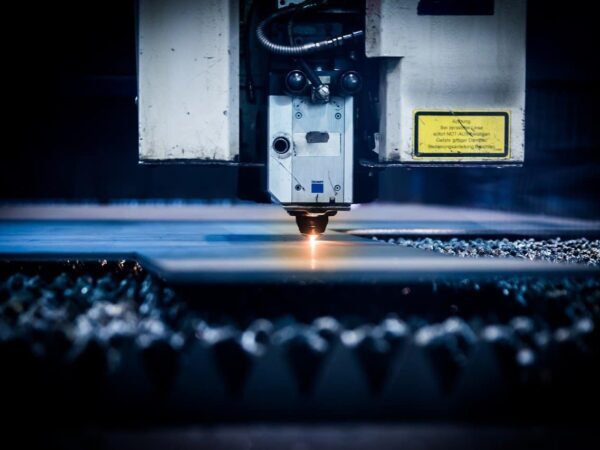 Laser cutter head cutting material, with a small glowing point of light