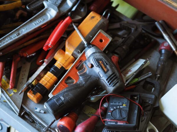Jumbled pile of hand tools, power tools and electrical testers