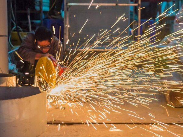 Grinding metal with sparks | Science Safety Worker grinding metal and throwing a shower of sparks