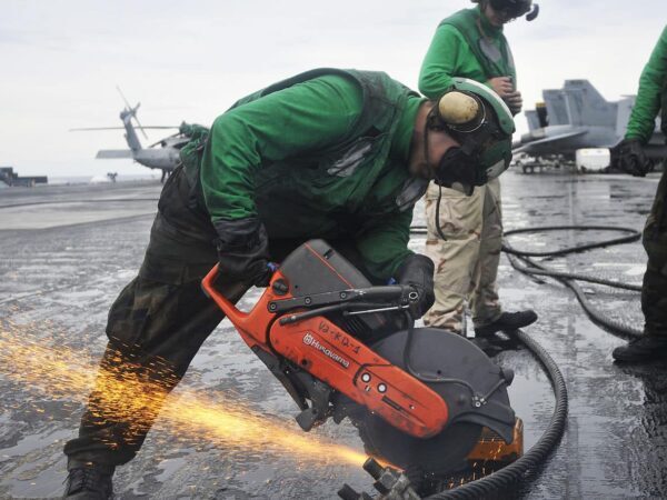 Sailor cutting a cable with a chop saw (U.S. Navy) | Science Safety Sailor in protective gear cutting a steel cable with a chop saw, sparks flying, on a ship deck