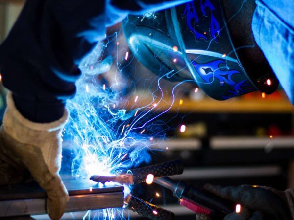 Welder working amid bright blue sparks