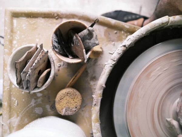 Potter’s wheel with clay tools and a cup of slip, seen from above