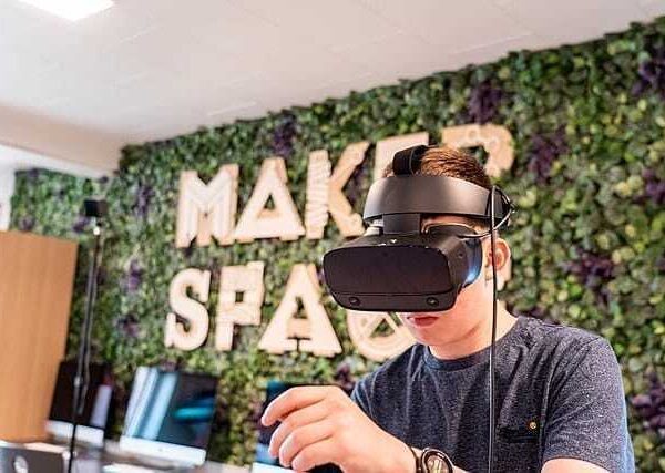 Student wearing a virtual reality headset in a makerspace