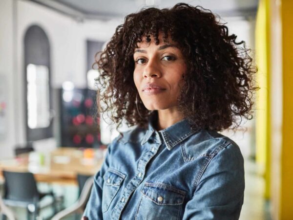 Portrait of a woman with curly hair in a denim shirt
