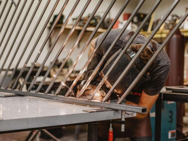 Welding a metal frame | Science Safety Welder working on a frame of metal bars in a workshop