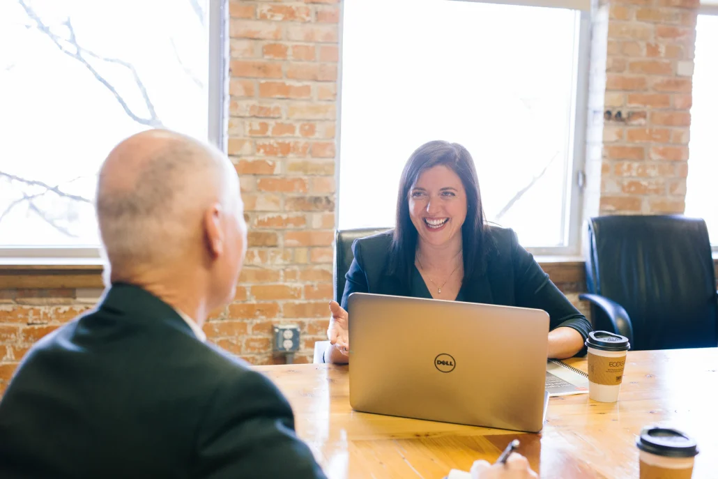 Meeting at an office table | Science Safety | Science Safety Woman with a laptop talking with a man across an office table