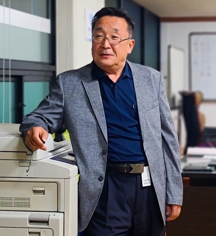a man standing next to a printer in an office